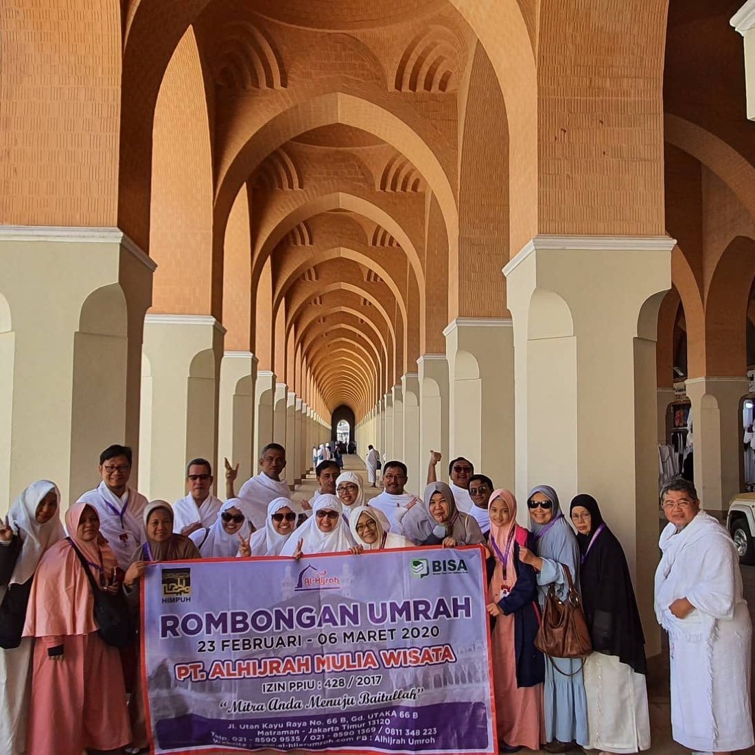 Rombongan jamaah berfoto membawa spanduk Rombongan Umrah di bawah deretan pilar Masjid Nabawi